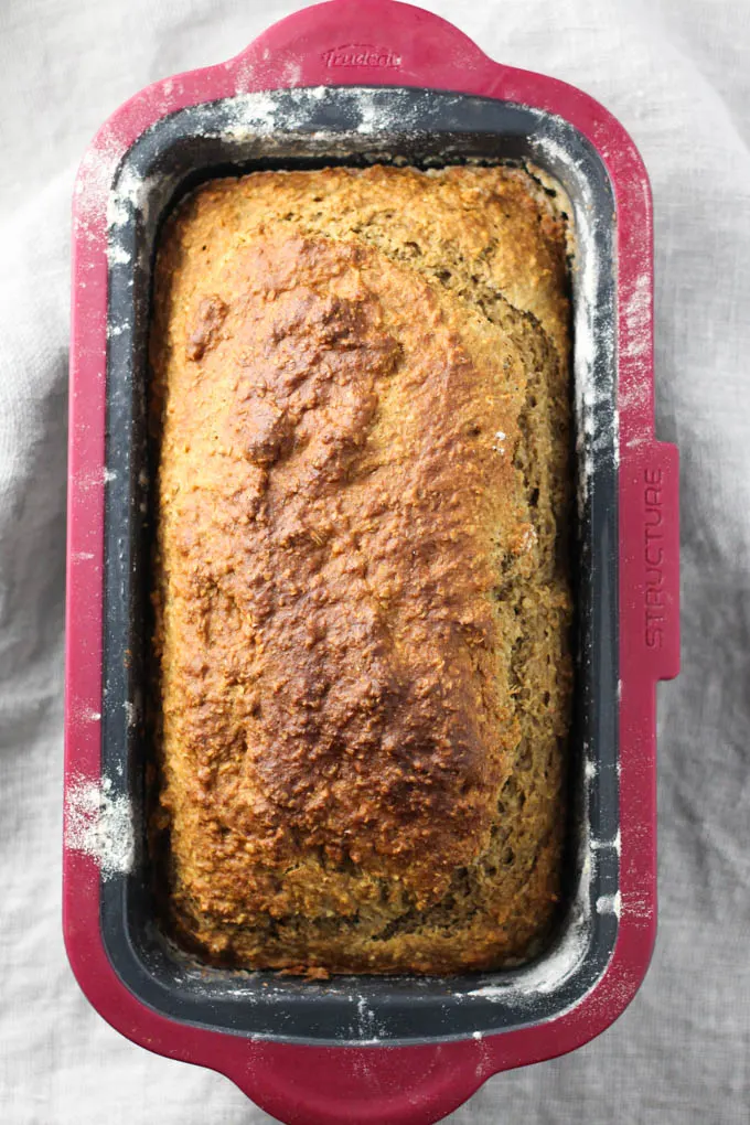Top view of the baked banana bread inside a loaf pan. The edges of the pan a slitly dusted with flour.