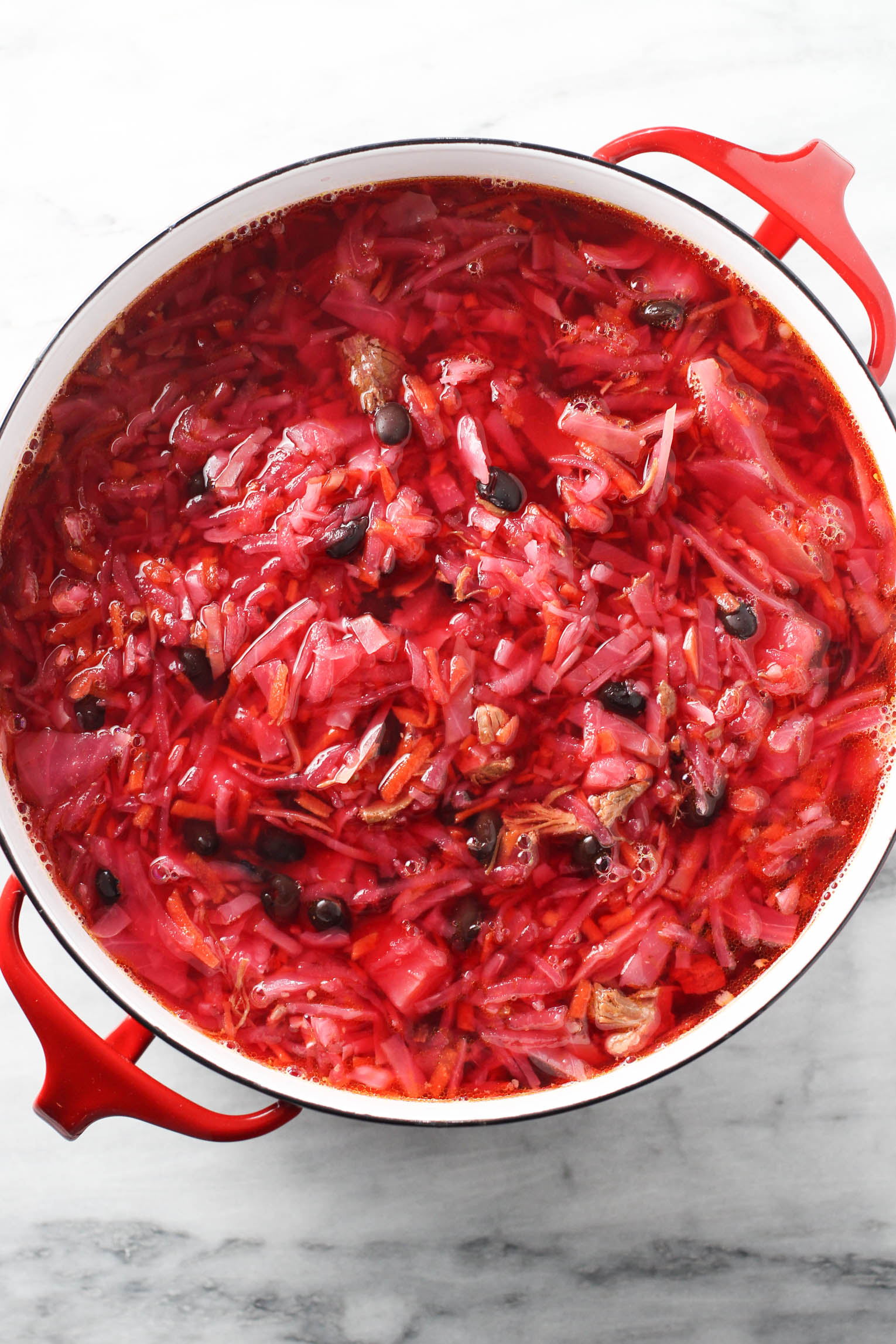 Overhead shot of borscht in a soup pot.