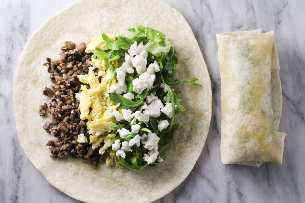 Tortilla wrap topped with mushrooms, eggs, goat cheese and arugula.