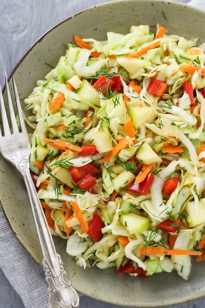 Healthy cabbage salad on a plate with a silver fork on the right side.