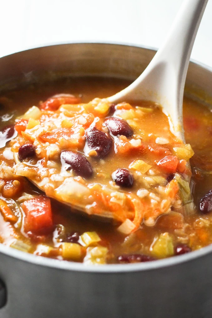 Close up shot of the bulgur vegetable soup in a ladle.