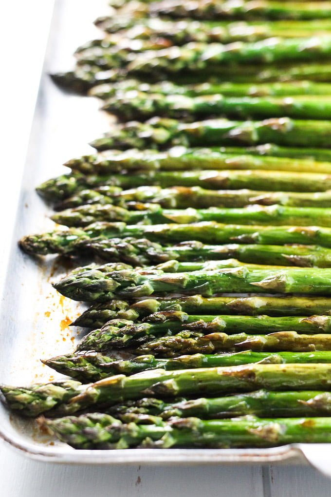 Roasted asparagus with balsamic vinegar on a baking sheet.