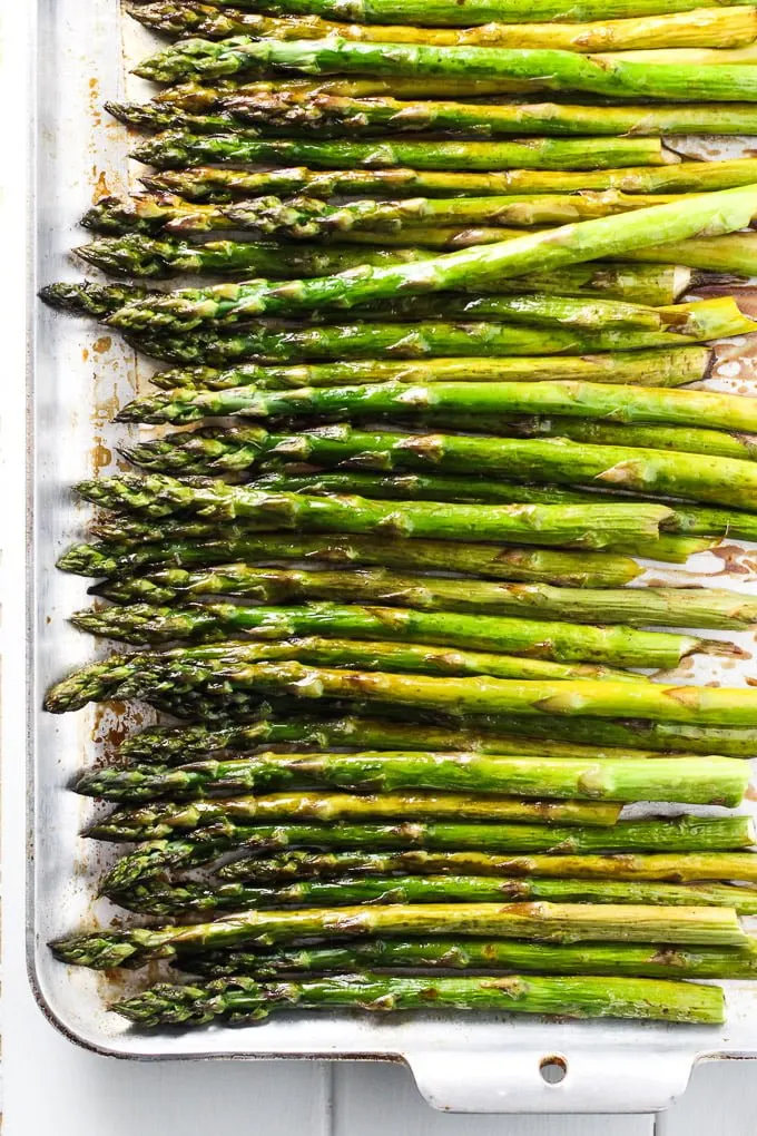 Roasted asparagus with balsamic vinegar on a baking sheet. Top view.