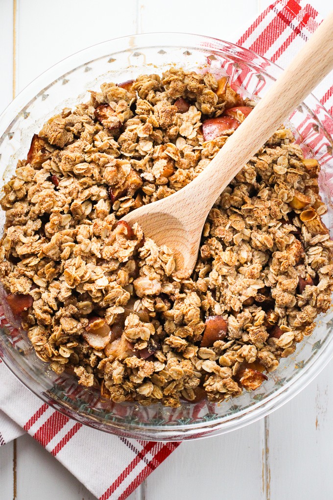 Healthy apple crisp in a glass baking dish standing on a tea towel.