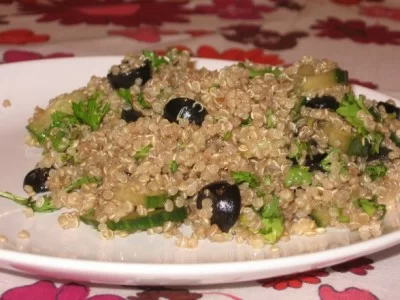 Quinoa salad with cucumber and black olives on a plate.
