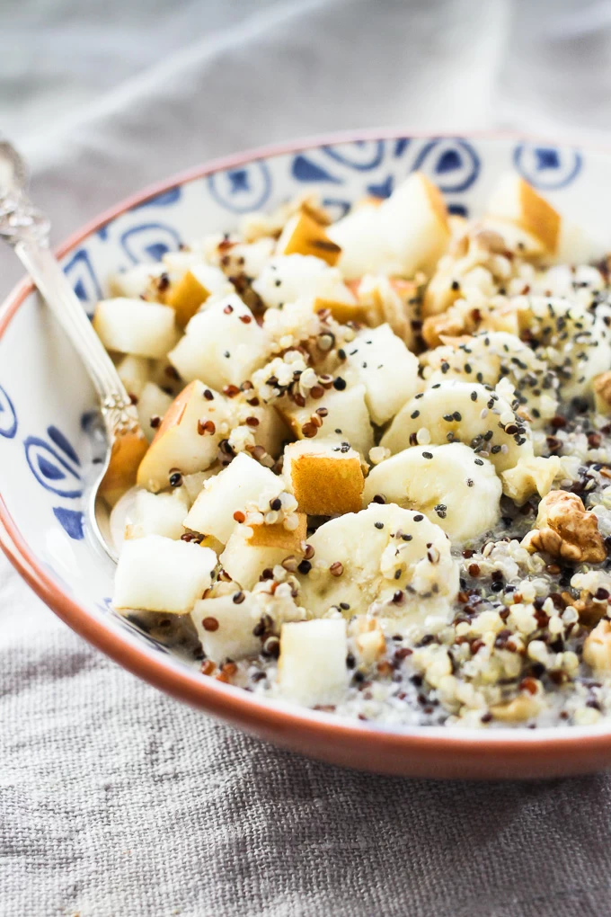 Quinoa breakfast bowl with banana and pear slices. Garnished with chia seeds.