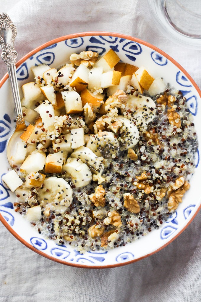 Overhead shot of quinoa with fruit, nuts, and chia seeds in a bowl.