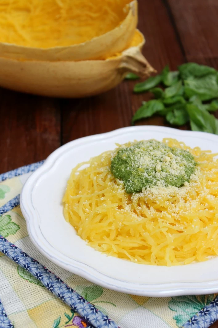 Spaghetti squash with basil pesto on a white plate.