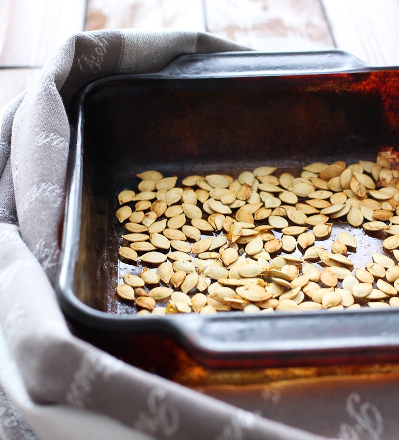 Roasted acorn squash seeds in a backing dish.