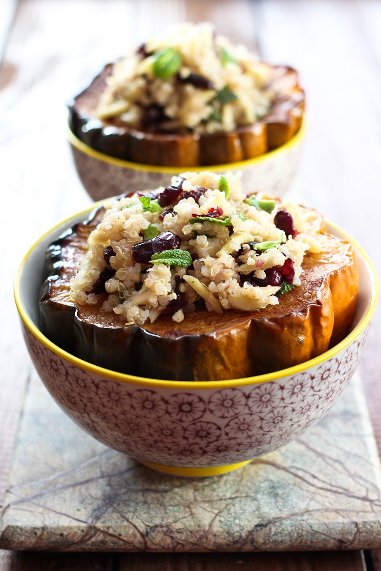 Roasted acorn squash stuffed with quinoa salad served in bowls.