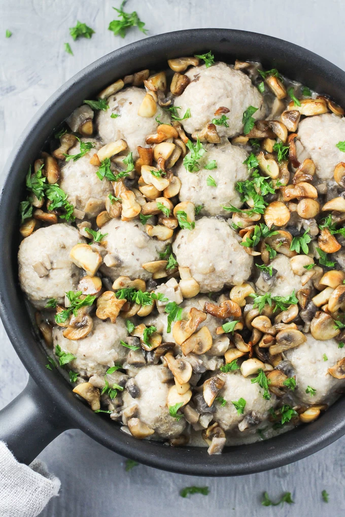 Turkey meatballs with dairy free mushroom sauce in a black skillet. Top view.
