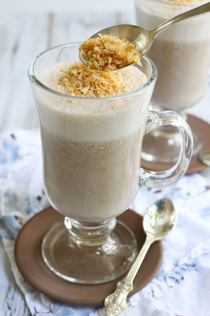 Healthy coffee smoothie in a glass, garnished with toasted coconut.