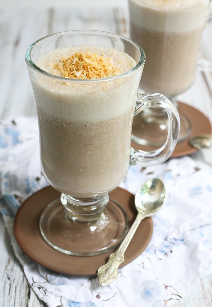 Healthy coffee smoothie garnished with toasted coconut in a tall glass.