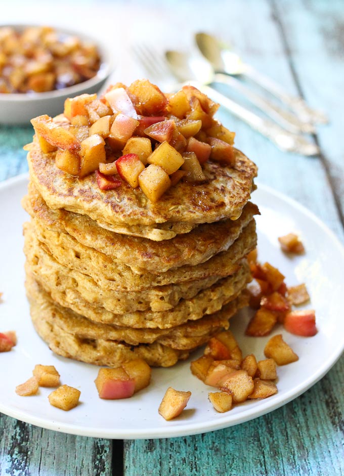 Healthy oatmeal pancakes with the apple topping on a white plate. 