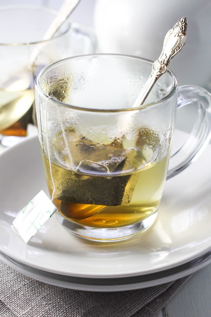 Jasmine green tea bag in hot water in a glass tea cup.