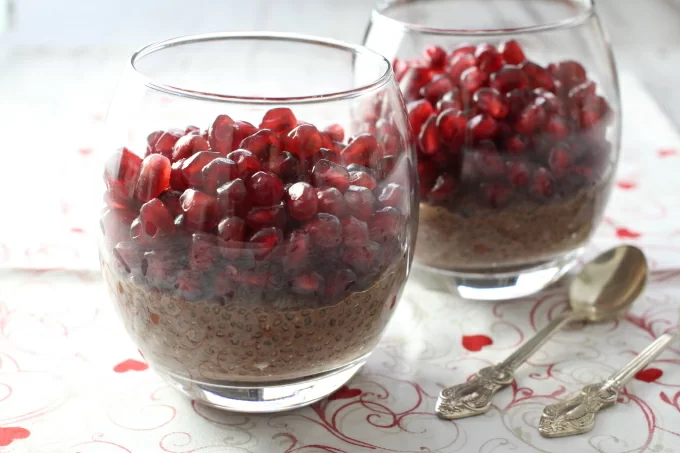 Chocolate chia pudding with pomegranate in glasses.