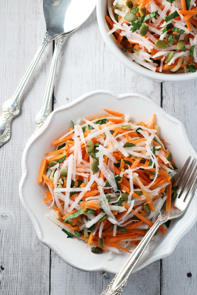 Turnip salad on a white plate with a silver fork to the right.