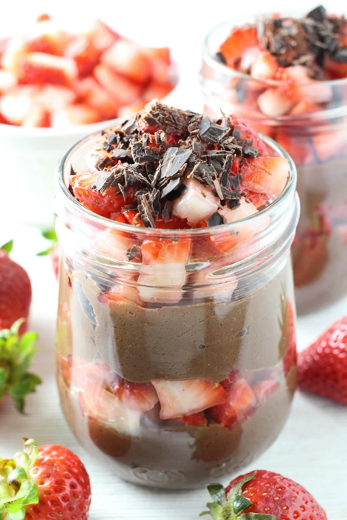 Coconut milk chocolate pudding in a jar, garnished with strawberries and chocolate shavings.