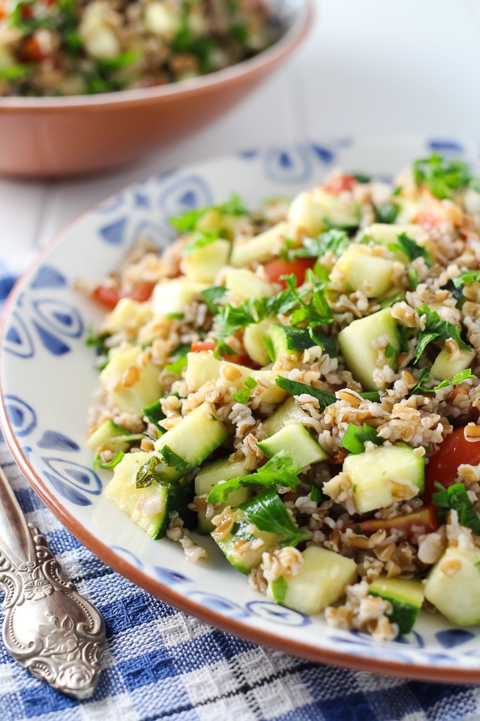 Zucchini tabbouleh salad on a plate standing on a kitchen towel.