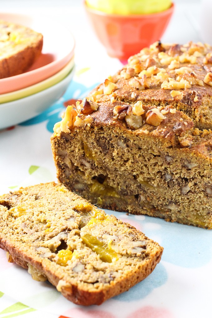 Clean eating mango bread loaf with one slice cut off.