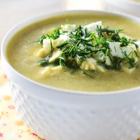 Dairy-free zucchini soup in white ramekins. Garnished with dill.
