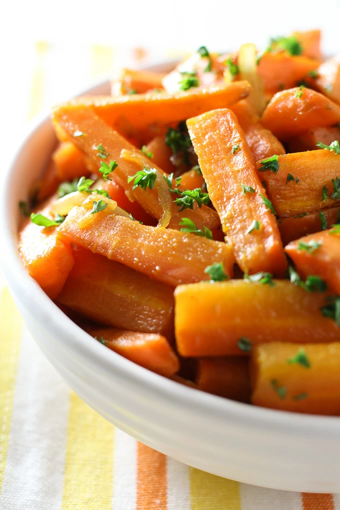 Roasted coriander carrots in a bowl garnished with chopped parsley.