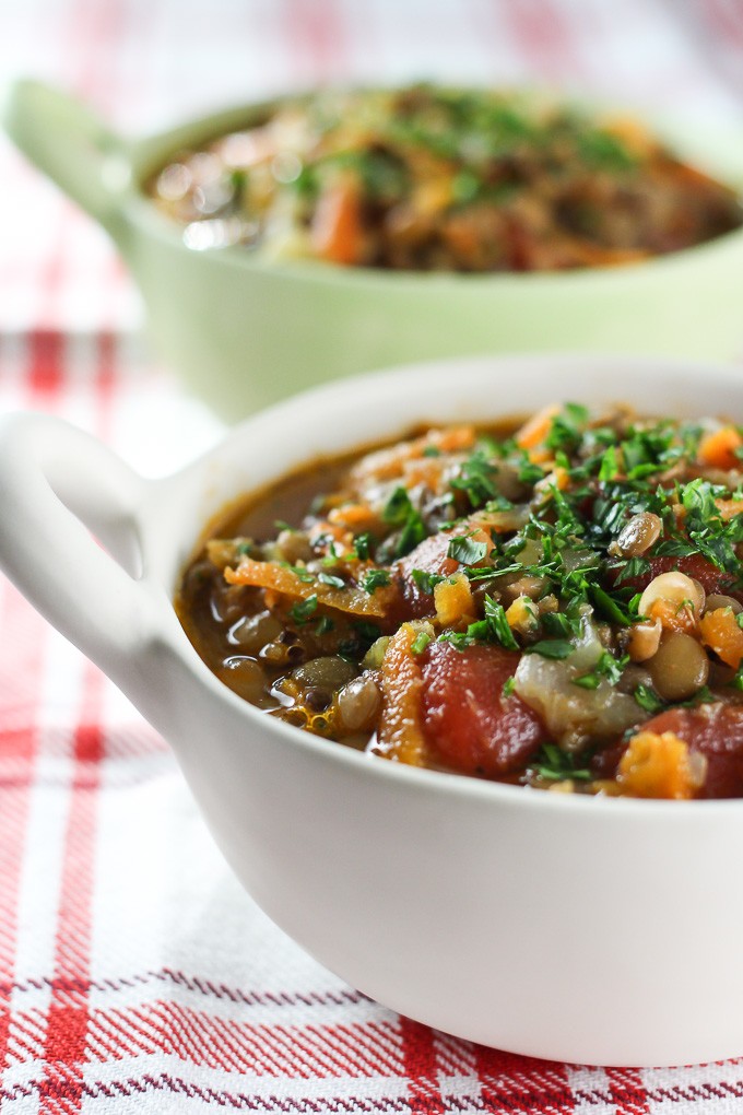 Close-up side view of the lentil soup in a bowl garnished with chopped parsley.