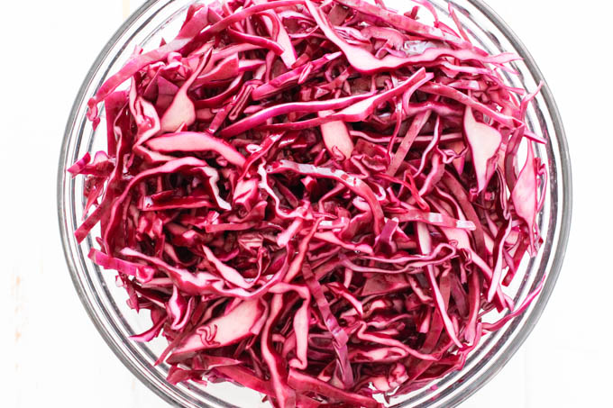Overhead shot of massaged red cabbage in a bowl.