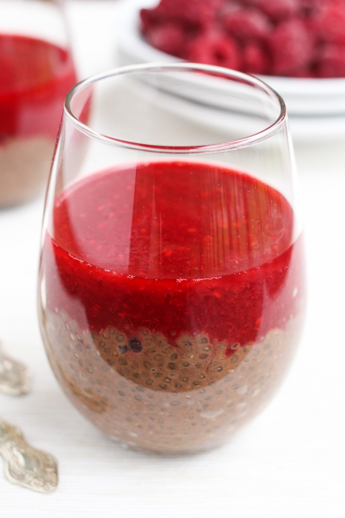 Chocolate chia pudding with raspberry sauce in a glass.