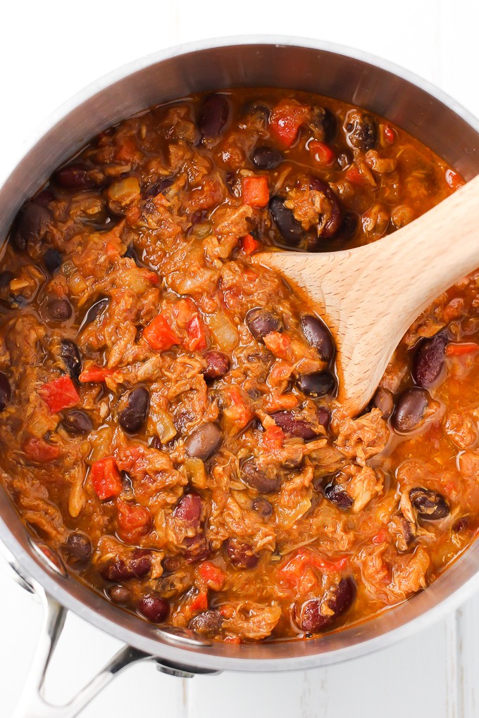 Tuna chili in a pot with a wooden spoon in it.