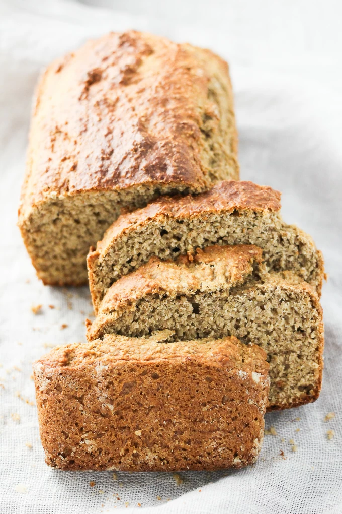 A loaf of the oat bran banana bread with three slices cut off.