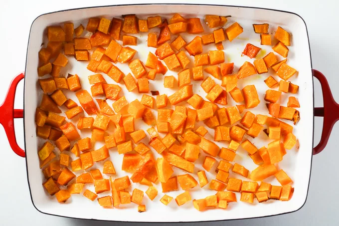 Top view of roasted butternut squash cubes in a baking dish.