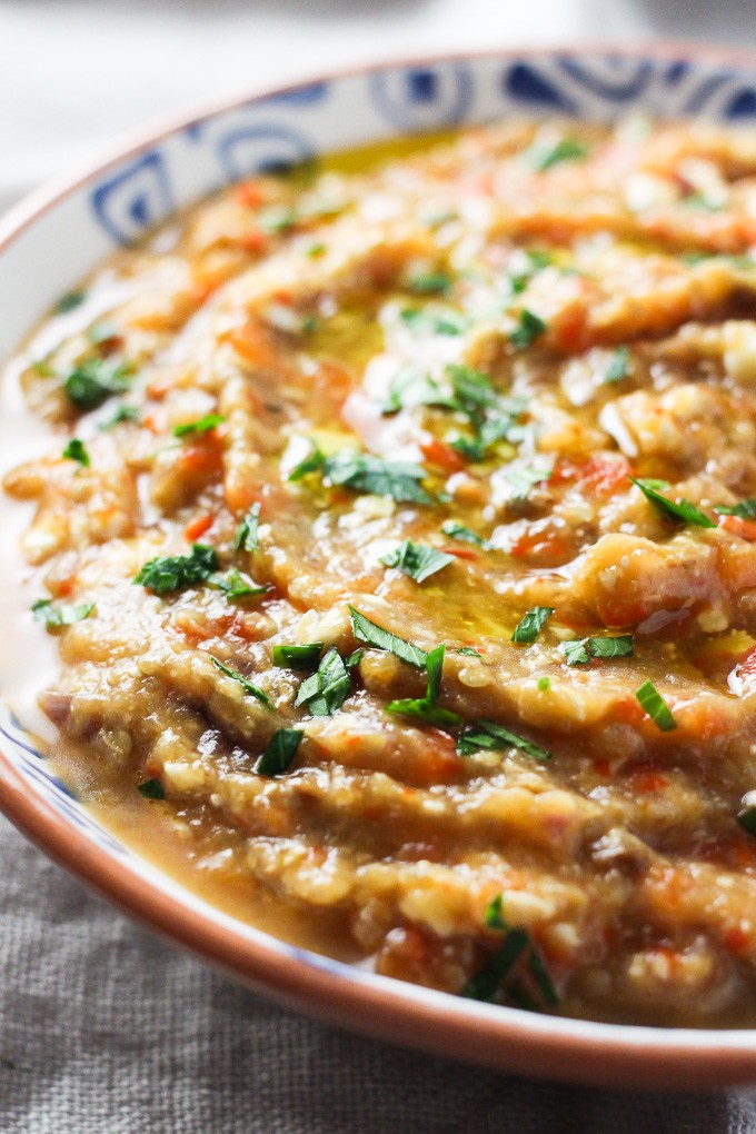 Roasted eggplant dip in a bowl, garnished with chopped parsley.