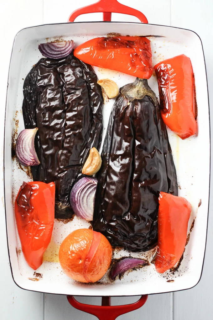 Roasted eggplant, tomato, red pepper, onion, and garlic in a baking dish.