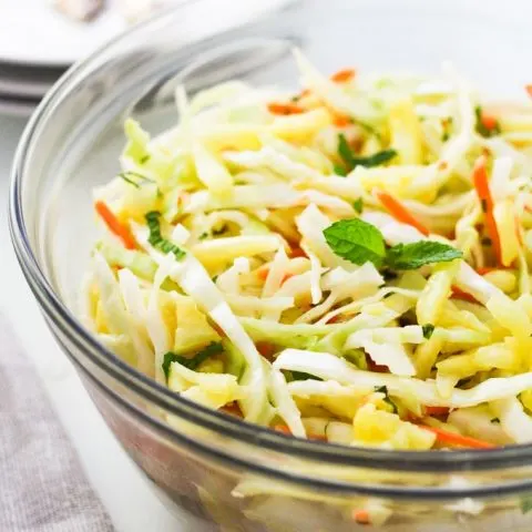 Pineapple coleslaw in a glass bowl.