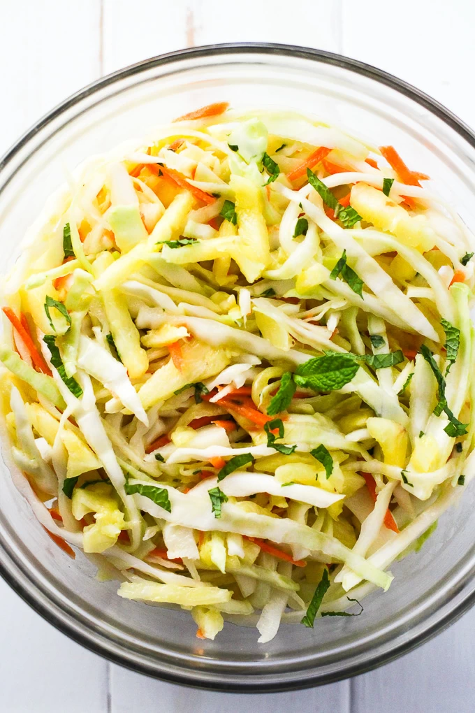 Crunchy pineapple coleslaw in a glass bowl, top view. 