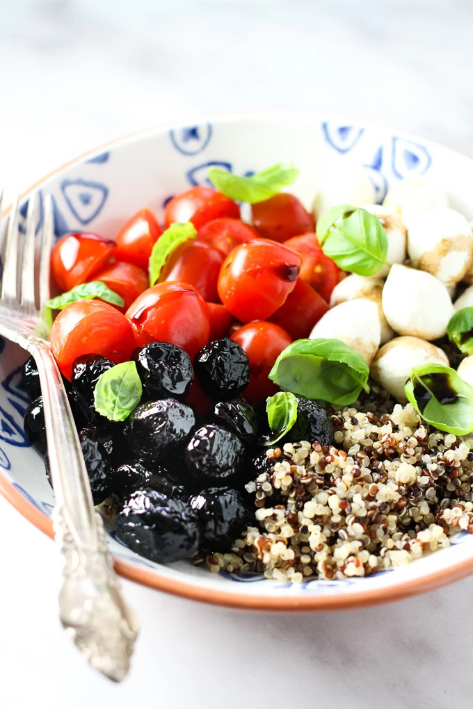 Caprese quinoa bowl with a silver fork on the left.