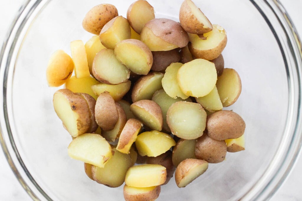 Sliced fork-tender boiled baby potatoes ready for potato salad.