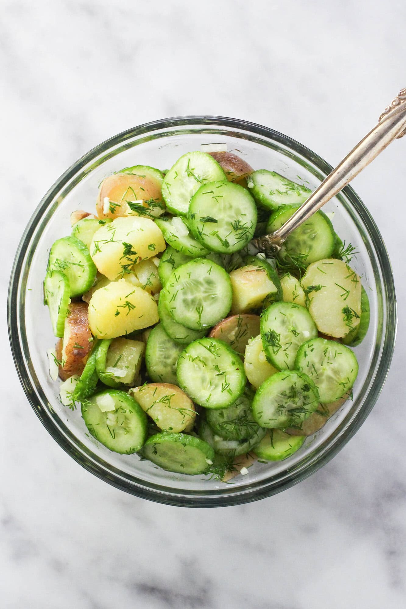 Fresh potato cucumber salad with dill and vinegar dressing in a bowl ready to serve.