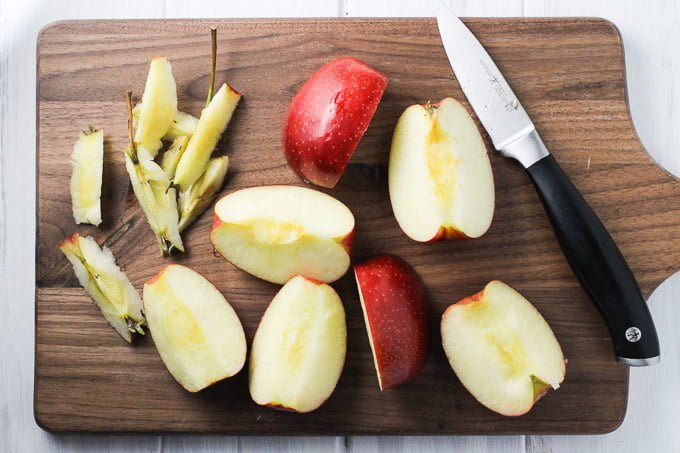 Sliced apples on a wooden cutting board.