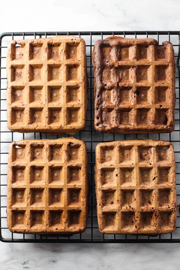 Four healthy chocolate waffles on a cooling rack. Top view.