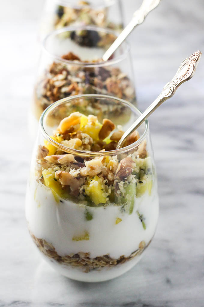 Yogurt parfait in glasses on marble background.