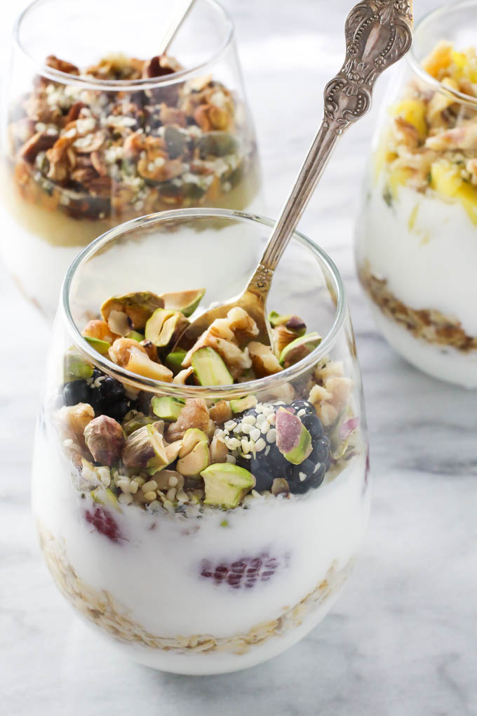 Mixed berries yogurt parfait in a glass with a silver spoon.