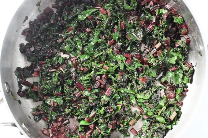 Wilted beet greens in a saute pan.
