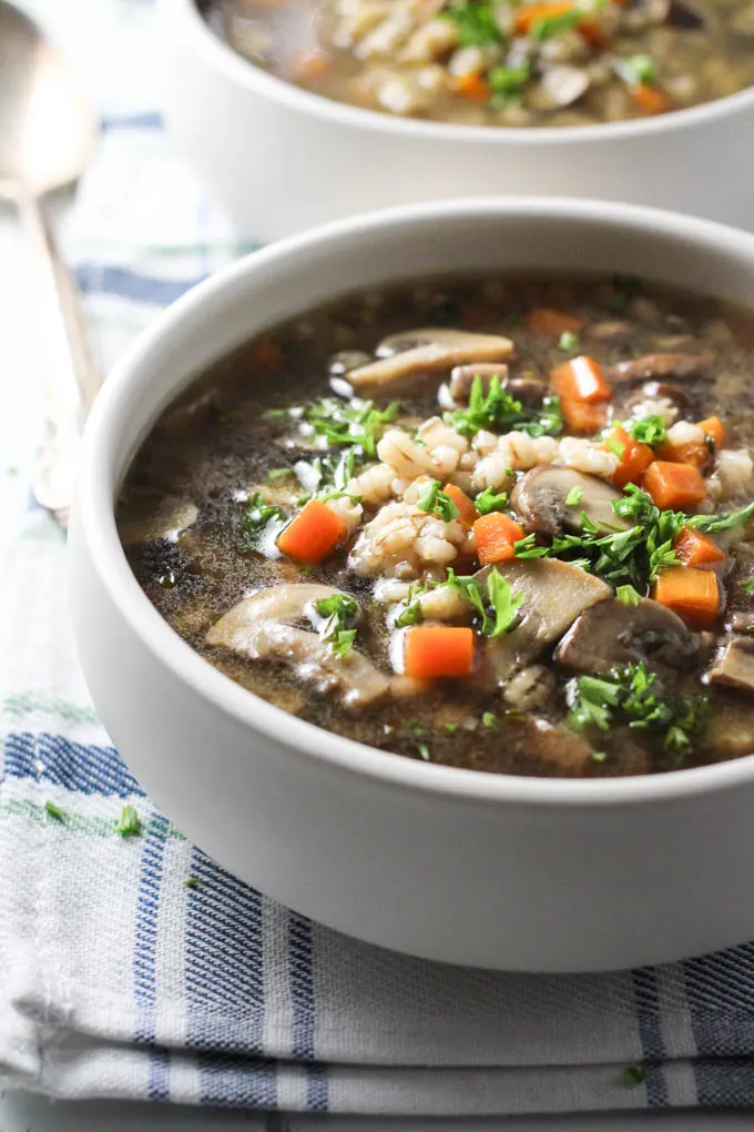 Instant Pot Barley Mushroom Soup in a bowl standing on a tea towel.