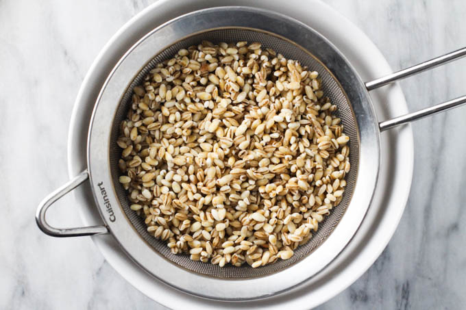 Washed pot barley in a mesh strainers.