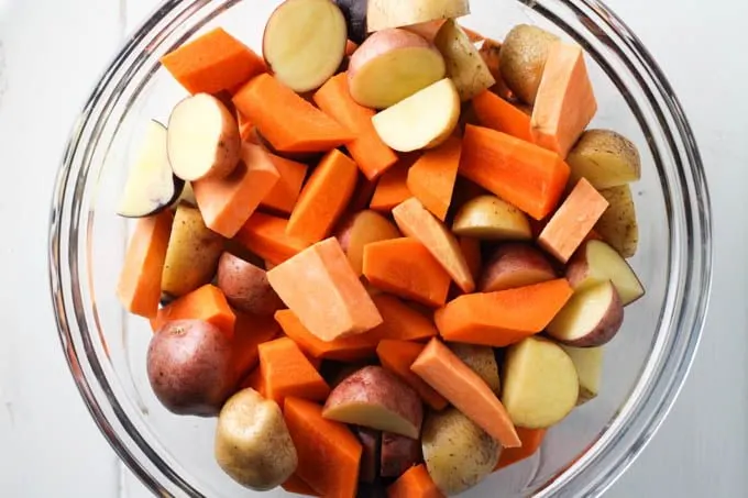 Chopped root vegetables in a glass bowl.