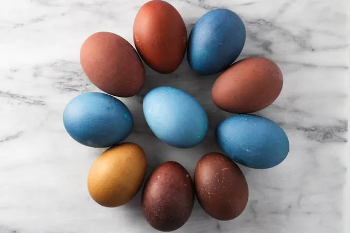 Colored Easter eggs arranged in a form of a flower on a marble background.