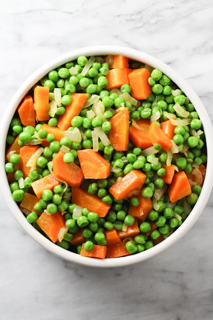 Peas and carrots in a bowl. Top view.