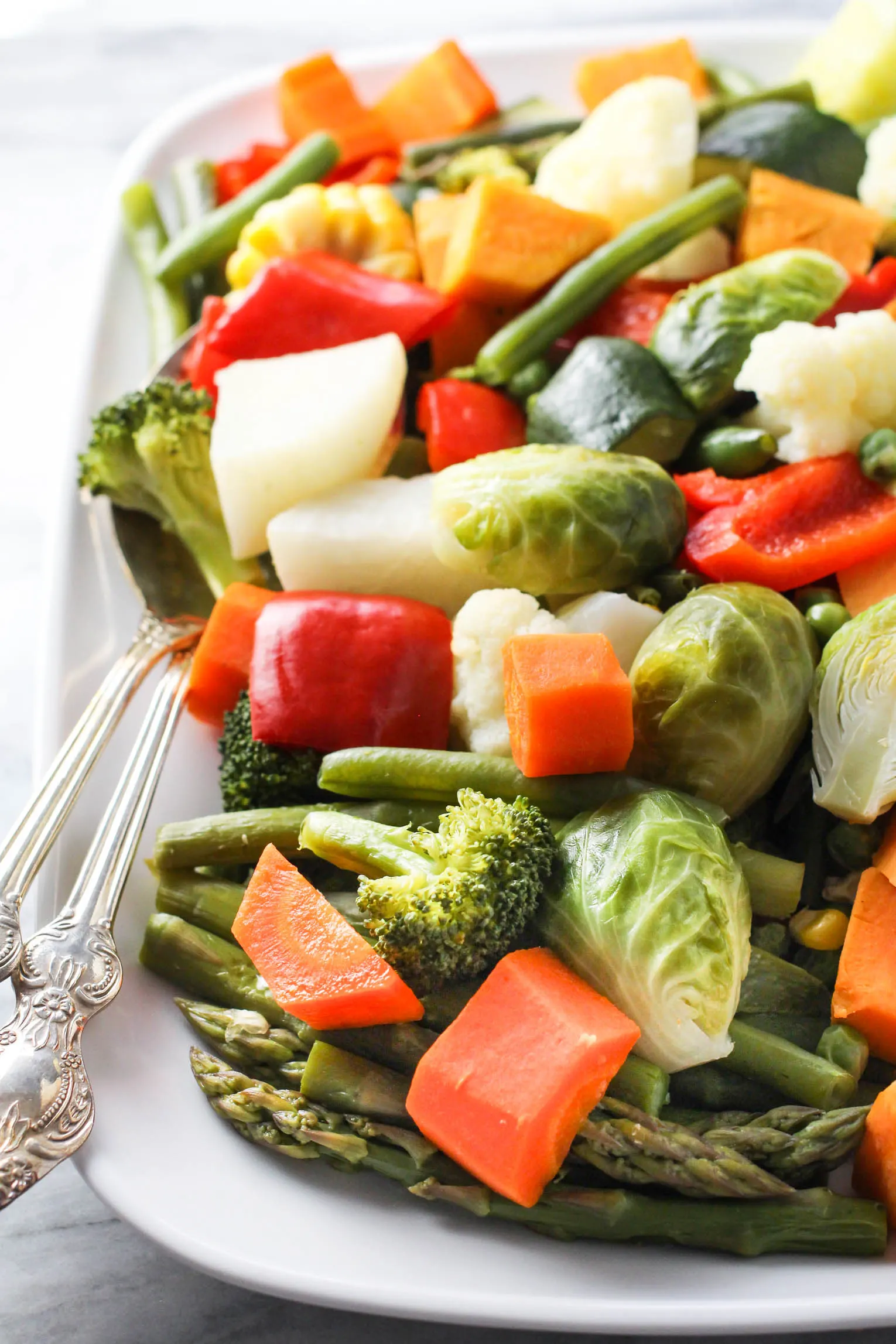 Steamed vegetables on a white platter.